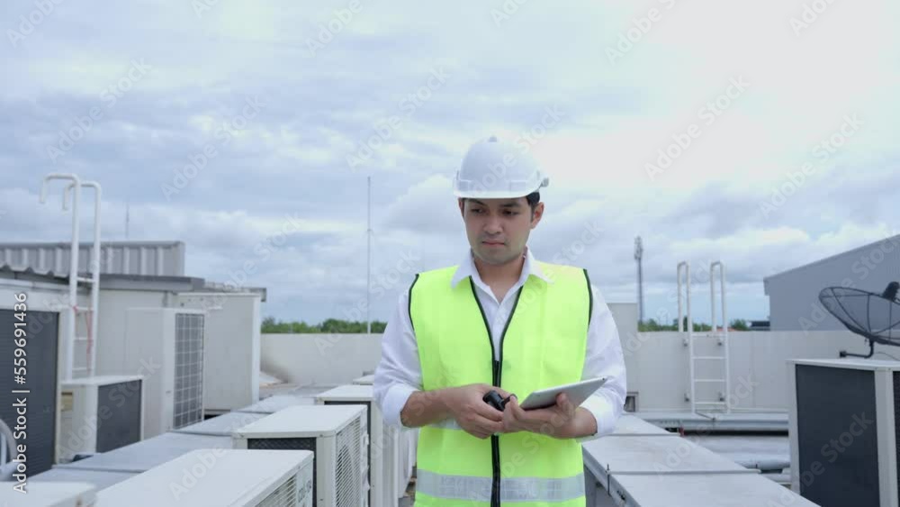 Asian maintenance engineer works on the roof of factory. contractor inspect compressor system and plans installation of air condition systems in construction. technology, online checking, mobile. Asian maintenance engineer works on the roof of factory. contractor inspect compressor system and plans installation of air condition systems in construction. technology, online checking, mobile.