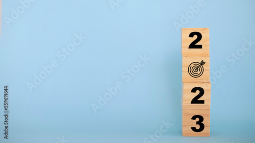 2023 Happy New year background banner. 2023 year numbers on wooden cube blocks stack on blue background with copy space. Concept of planning, goal, challenge, new year resolution..