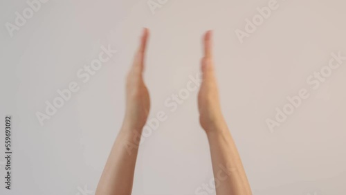 Woman's clapping her hands on white background and waving saying greeting, goodbye making hand gestures. message for advertisement, and promotional