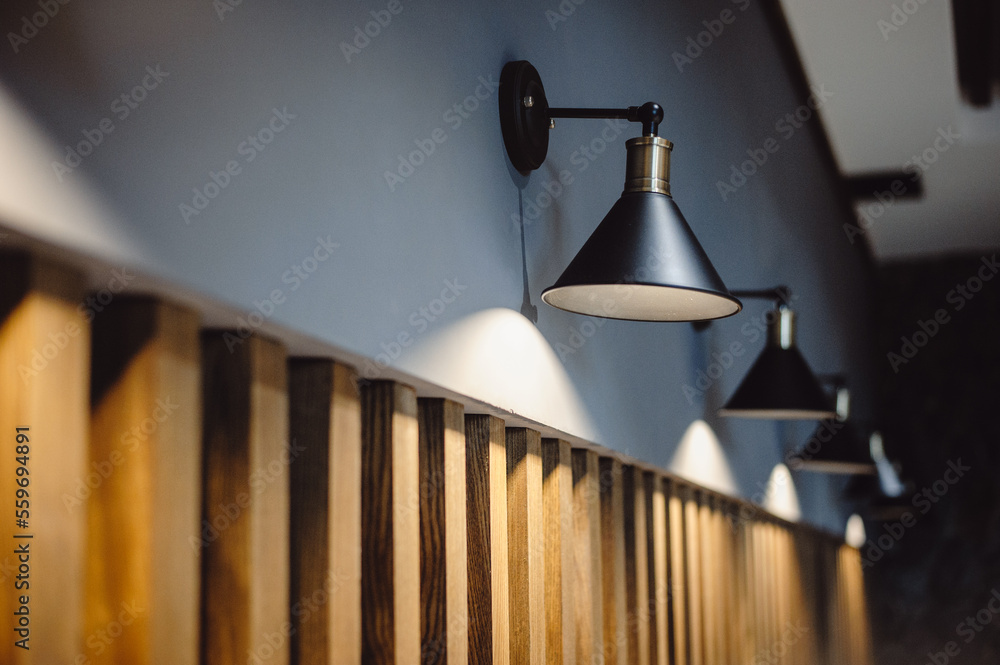 Black lamps indicate a gray wall decorated with wooden lines, background  for interior design. Interior decoration of stylish housing. Retro loft  style lamp. Home design in a modern style. film noise Stock