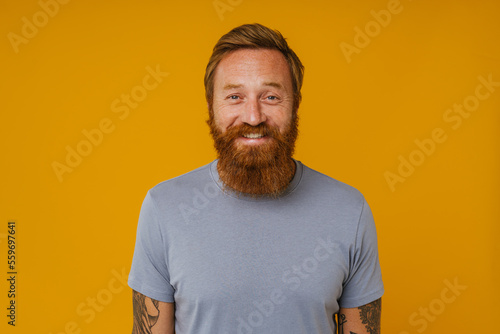 Bearded man posing at camera while standing isolated over background © Drobot Dean