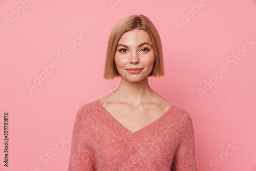 Beautiful woman posing isolated over pink wall background