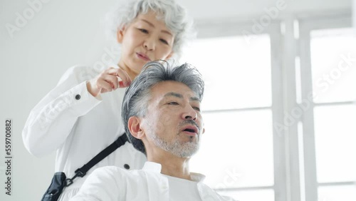 シニア男性をヘアセットするグレイヘアの美容師 photo