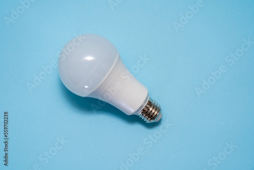 Energy saving light bulb on blue background. Savings