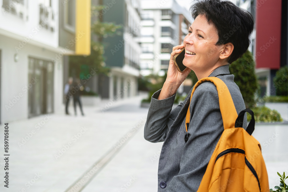 Happy woman with short haircut talks on phone Happy woman with short haircut talks on phone