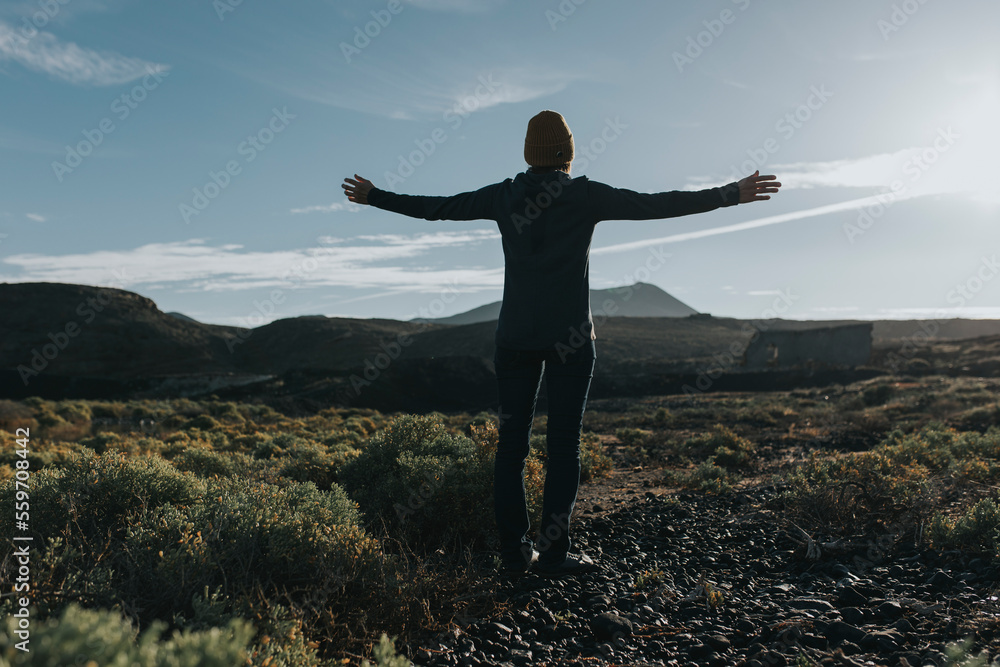 Woman with arms outstretched standing on land at Lanzarote, Canary Islands, Spain Woman with arms outstretched standing on land at Lanzarote, Canary Islands, Spain