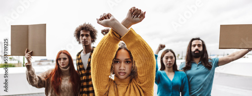 Serious activist making stop gesture with protestors in background