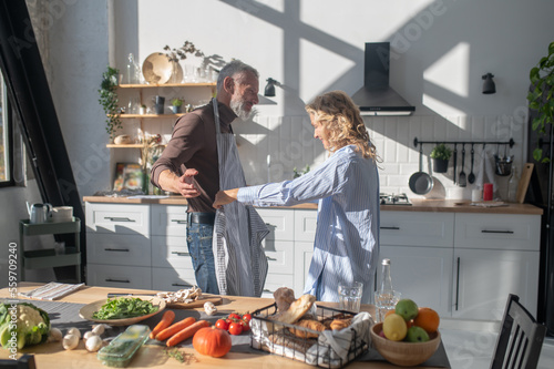 Mature couple feeling good while cooking together in the kitchen