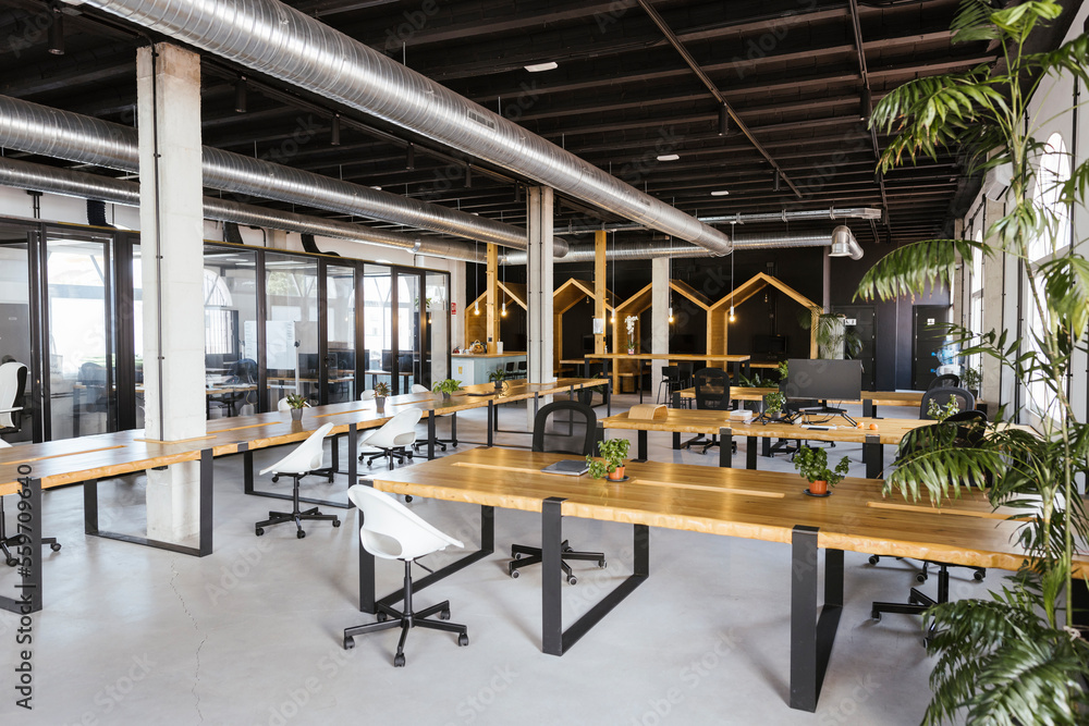 Interior of empty modern coworking office with desks and chairs Interior of empty modern coworking office with desks and chairs
