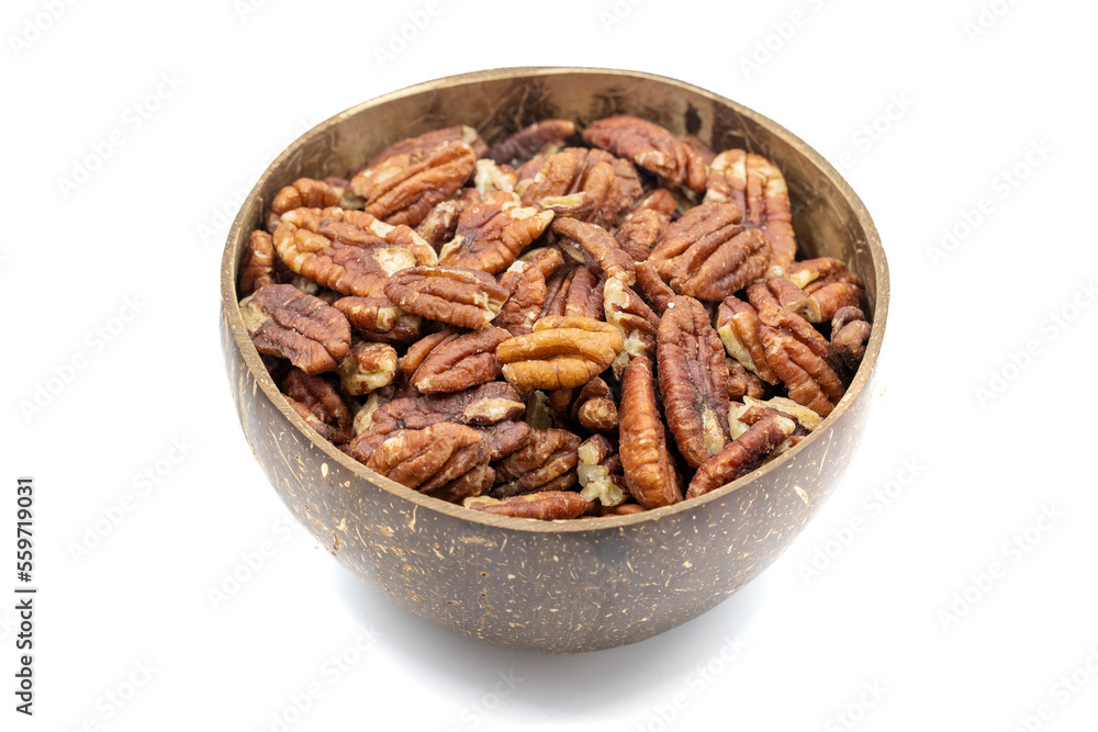 Pecan isolated on white background. Pecans in a coconut bowl. healthy fat. Heap shelled Pecans nut. Close up. Keto diet. Studio shoot. close up