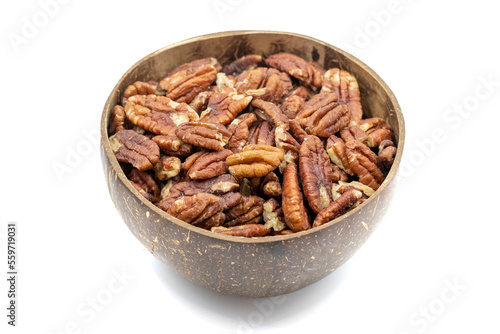 Pecan isolated on white background. Pecans in a coconut bowl. healthy fat. Heap shelled Pecans nut. Close up. Keto diet. Studio shoot. close up