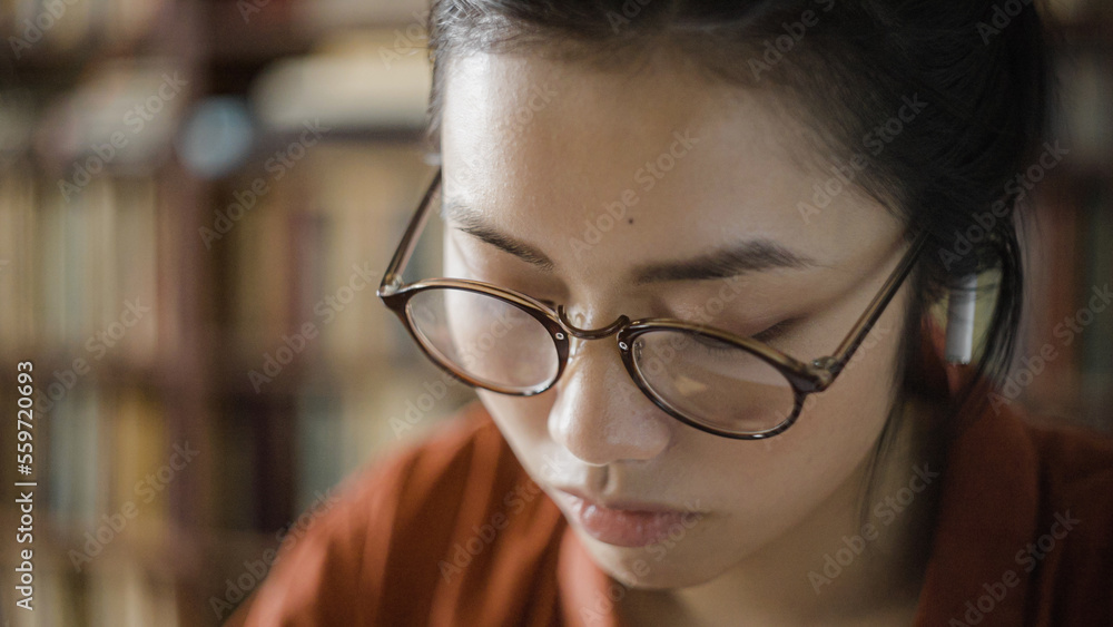 Close-up of focused young woman studying or working on laptop, writing down notes Close-up of focused young woman studying or working on laptop, writing down notes