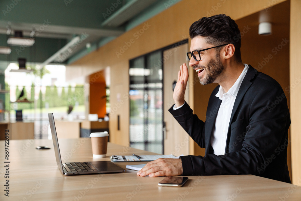 Young businessman in formal wear using laptop while working at office Young businessman in formal wear using laptop while working at office