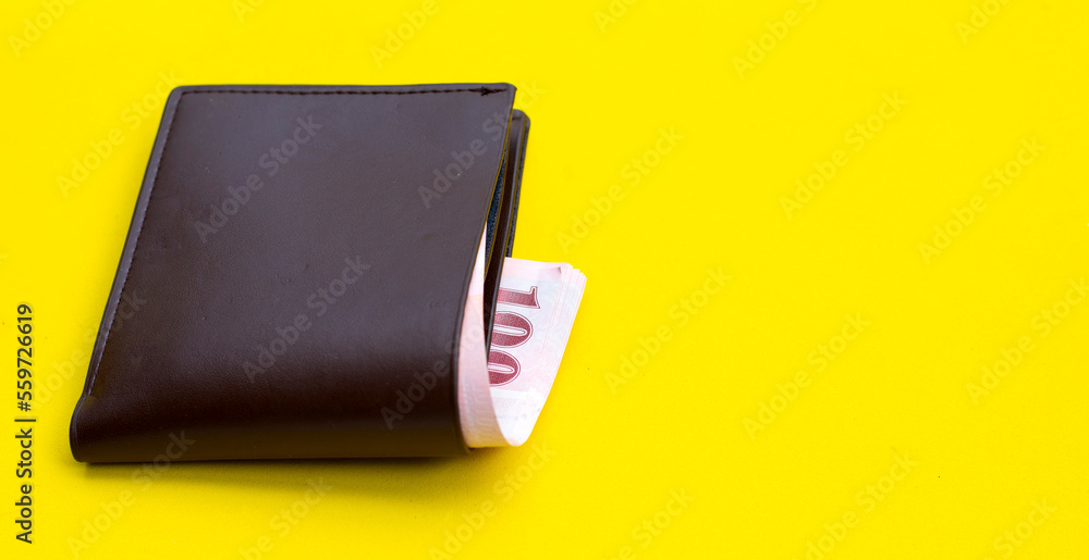 Brown wallet on yellow background Brown wallet on yellow background