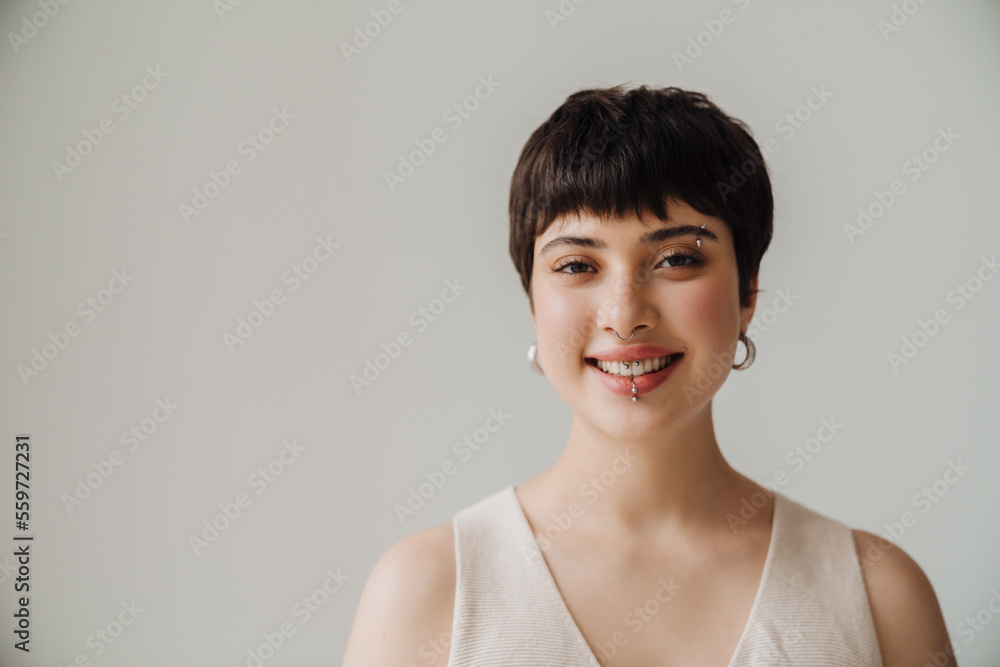 Young woman smiling at camera while standing indoors Young woman smiling at camera while standing indoors