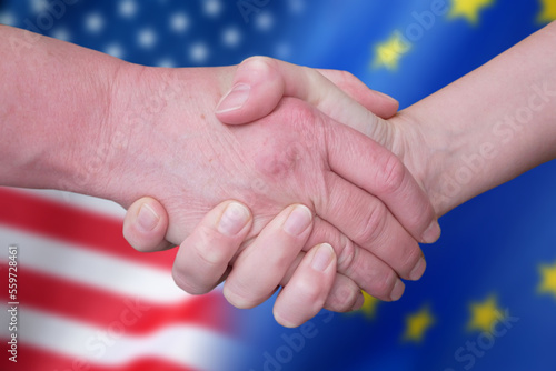 Handshake and European Union and United States flags, blue european union EU flag and half usa united states of america flag, concept