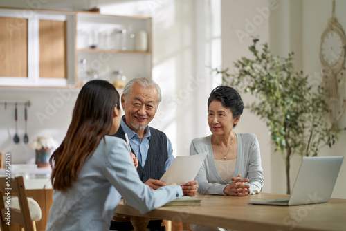asian sales woman selling product to old couple
