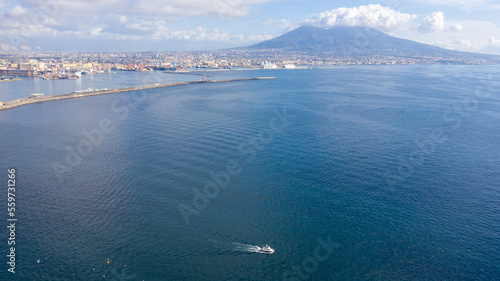 Aerial view of the port of Naples  Italy. In the background the Vesuvius volcano which dominates the panorama. A small boat crosses the gulf.