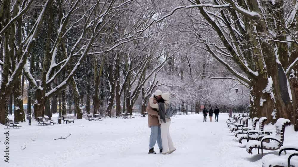 couple having date in city public park took a walk at winter snowed day