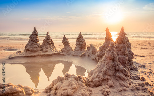 Sandcastle on the beach with warming light and beautiful sunset sky in summer vacation time