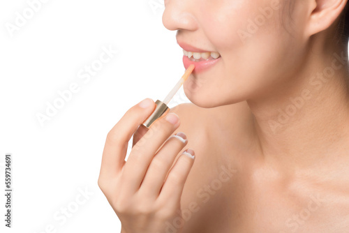 Beautiful portrait young asian woman looking mirror applying makeup lipstick at room. clipping path
