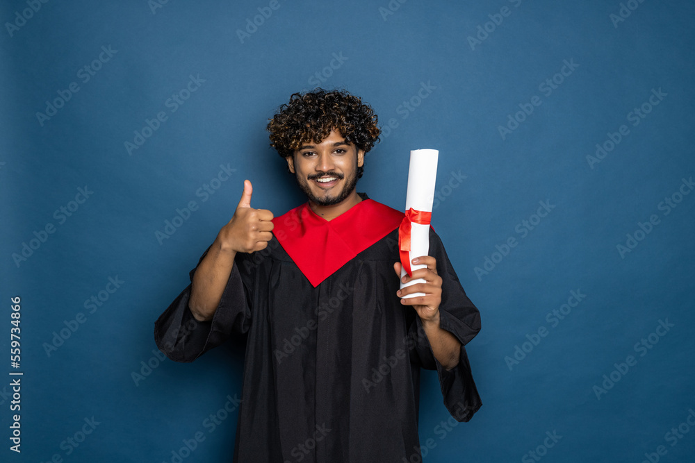 education, graduation and people concept. happy Indian Male graduate student in mortarboard and bachelor gown education, graduation and people concept. happy Indian Male graduate student in mortarboard and bachelor gown