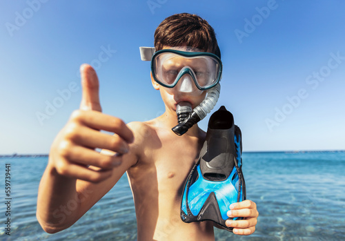 Portrait of a smiling little boy with scuba mask and snorkel by the sea