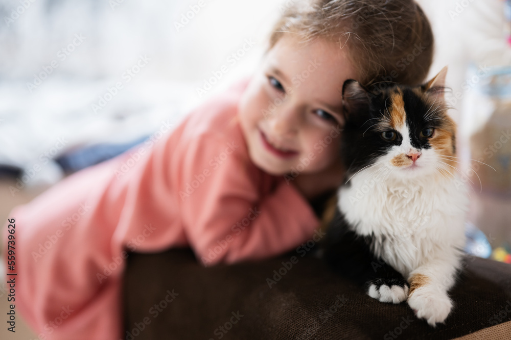 Baby girl with kitty lying on the sofa. Children's love for pets. Baby girl with kitty lying on the sofa. Children's love for pets.