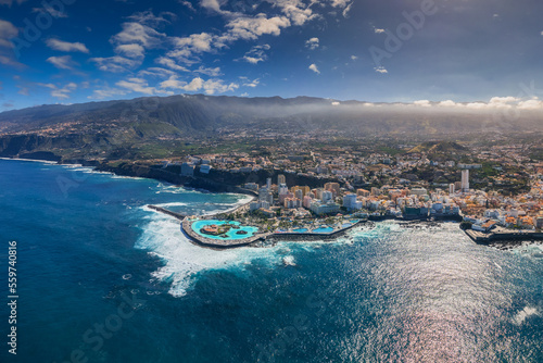 Aerial view of the city of Puerto De la Cruz and the surrounding coast. Sunny weather highlights the colors of the water.