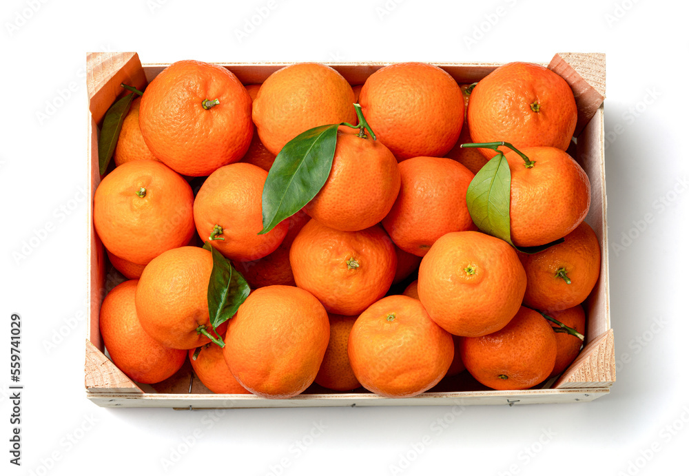 Orange tangerines with green leaves in a wooden box. Top view. Isolated on white background.