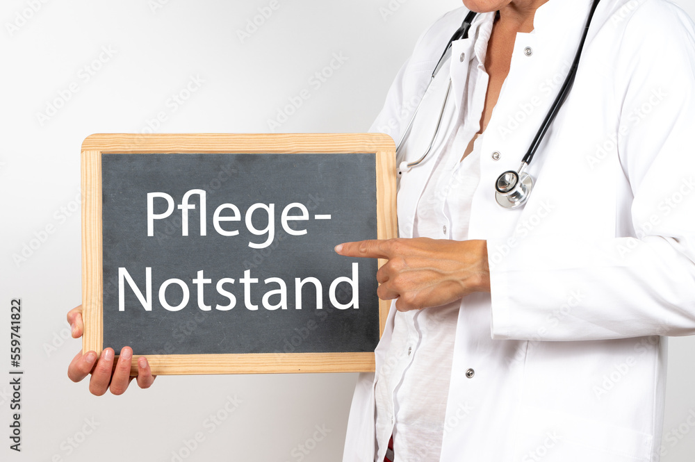 Ärztin mit einer Tafel auf der Pflege Notstand steht Ärztin mit einer Tafel auf der Pflege Notstand steht