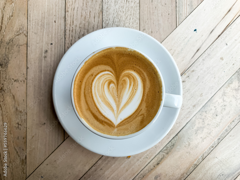 A cup of coffee latte on a wooden table. A mug of flat white coffee, latte, cappuccino on a wooden background. Coffee art. Heart flower shape latte art A cup of coffee latte on a wooden table. A mug of flat white coffee, latte, cappuccino on a wooden background. Coffee art. Heart flower shape latte art