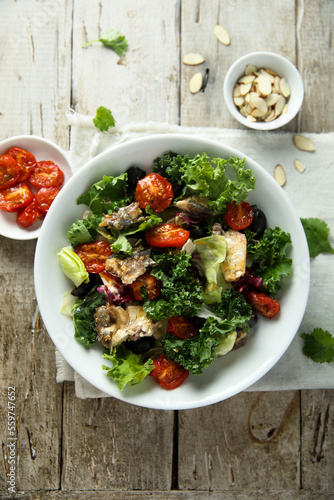 Healthy green salad with roasted tomatoes and fish