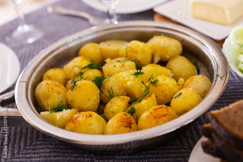 toasted young potatoes with dill in metal skillet