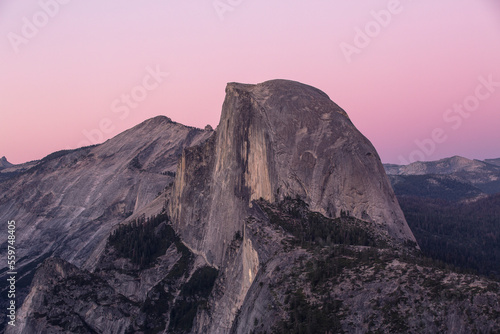 Half dome rock glowing purple and pink at sunset photo