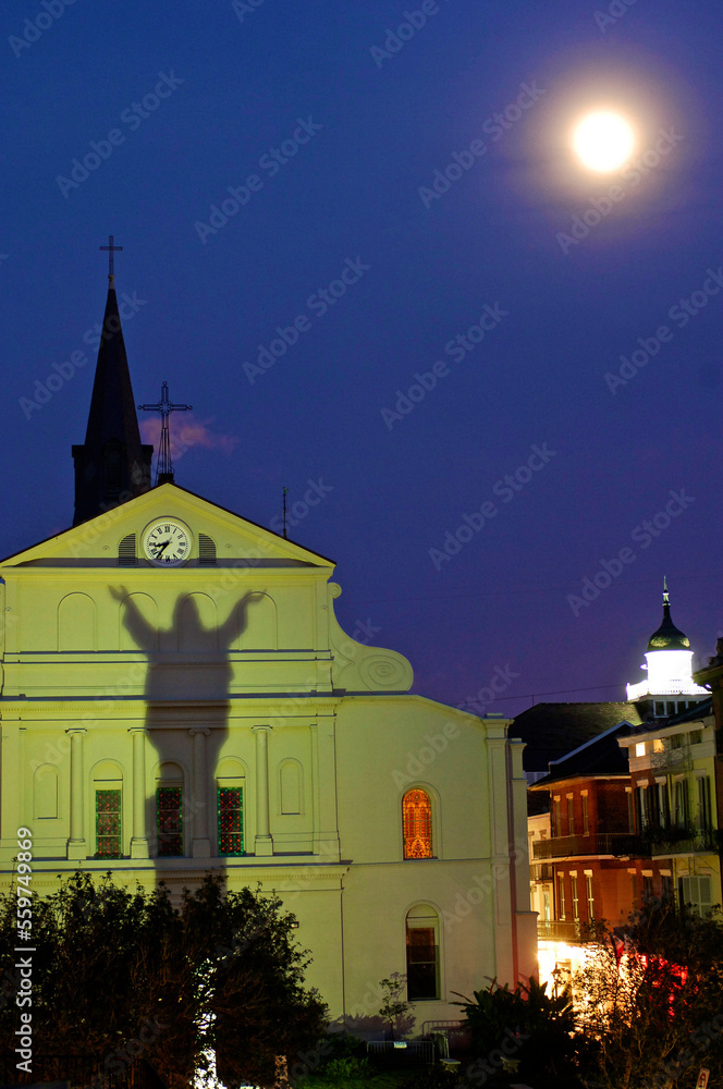 Statue of Jesus Christ casts a shadow on the back of St Louis Cathedral