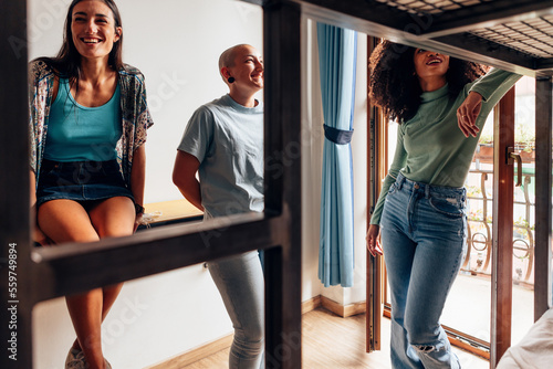 group of female students of different ethnicities talking together in college room - young ladies in youth hostel