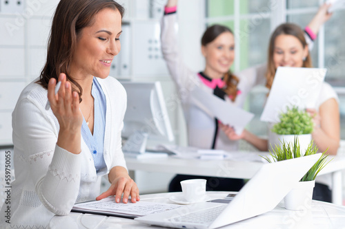 young women sit at the table and work in a modern office