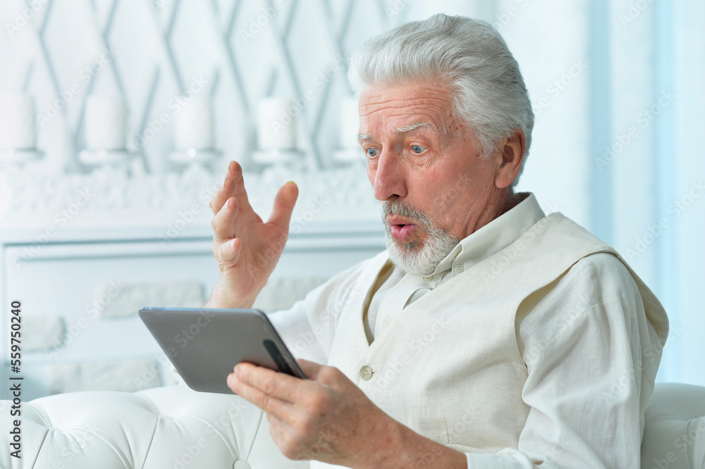 thoughtful senior man using tablet at home thoughtful senior man using tablet at home