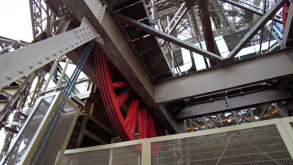 Rotating Lift Drive Wheel Of The Eiffel Tower In Paris, France. Low Angle Rotating Lift Drive Wheel Of The Eiffel Tower In Paris, France. Low Angle