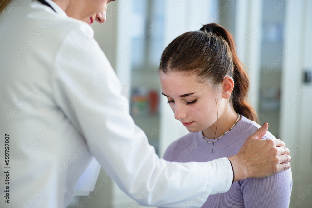 Close-up of doctor consoling unhappy teenage girl in her ambulance office.