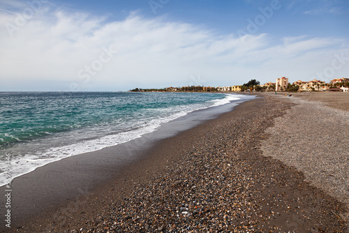 Spanish sea beach in the town of Motril with clear water and a small pebble beach. photo