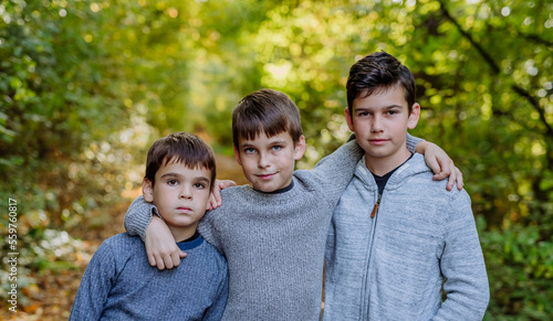 Konstfotografi Portrait of three boys, brothers standing in forest.