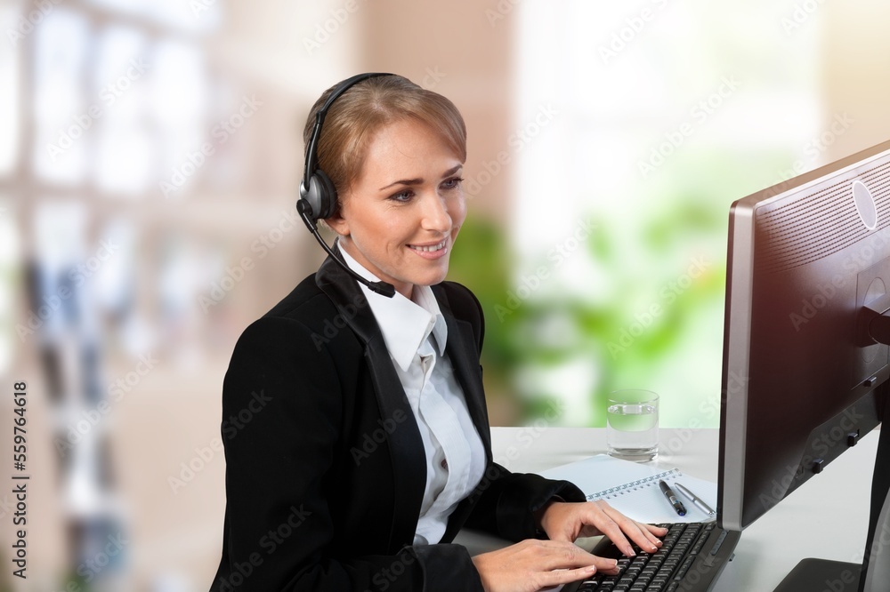 Young woman sitting and working on computer in modern office. Young woman sitting and working on computer in modern office.
