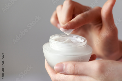 Girl holding a jar of cosmetic cream, with copy space