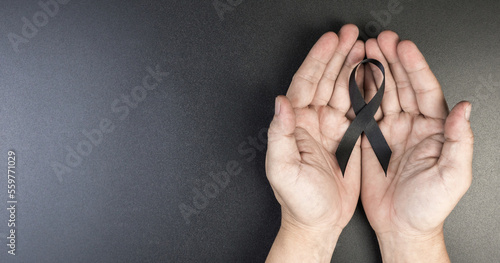 Fotografia Hand hold black ribbon on background