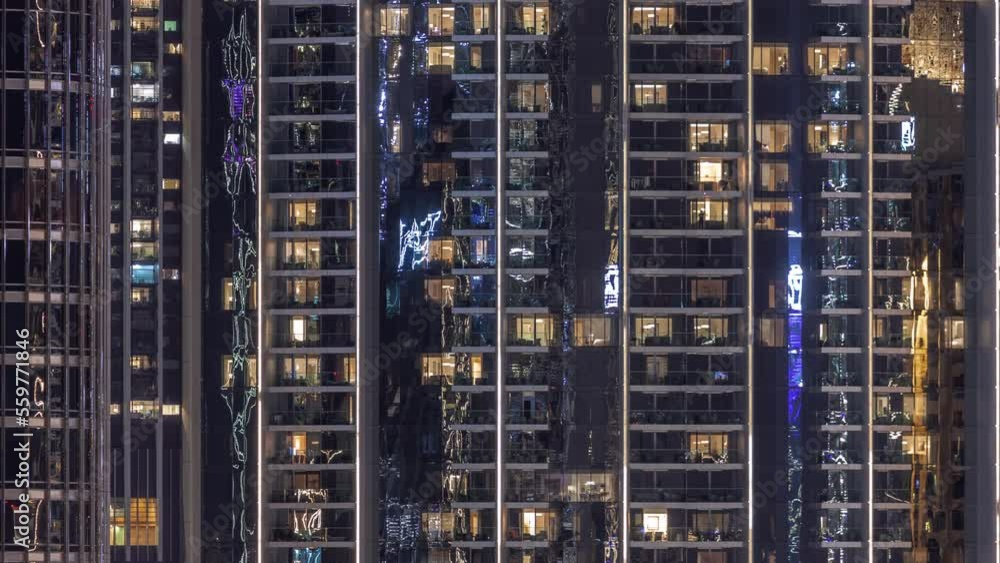 Night view of many glowing windows in apartment building timelapse. High rise skyscraper with lights in rooms. Evening illumination Night view of many glowing windows in apartment building timelapse. High rise skyscraper with lights in rooms. Evening illumination