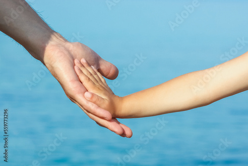 beautiful hands of parent and child by the sea