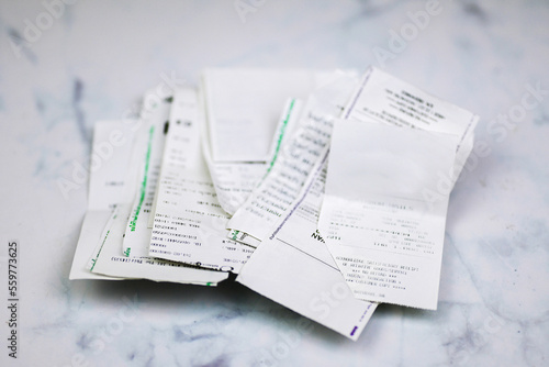Pile of shopping receipts and credit card slips on white background. Debt and household expenditures.