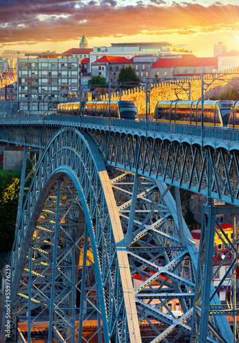 Porto, Portugal. View at Ponte de Dom Luis Bridge on river Douro. Passenger trains moving by the during evening sunset
